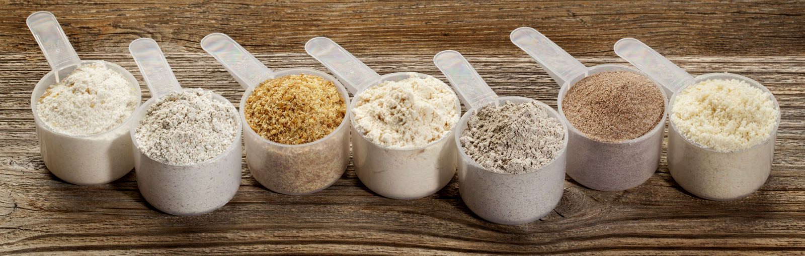  Seven measuring cups in a line filled with ingredients 