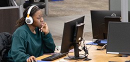 Foto: Studentin mit Kopfhörern arbeitet an einem Bibliothekscomputer